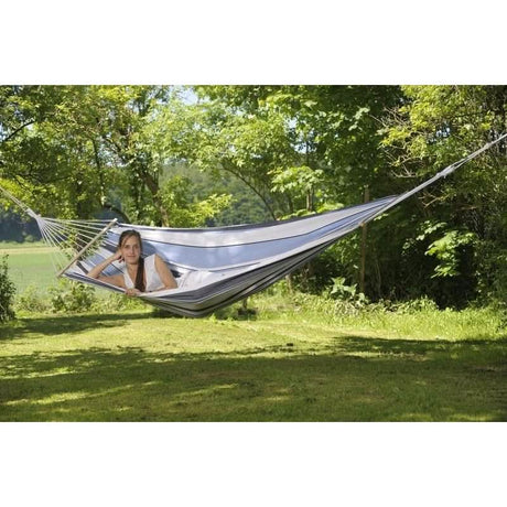 Person relaxing in a hammock surrounded by greenery