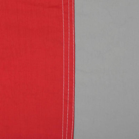 Close-up of red fabric with white stitching on a grey background